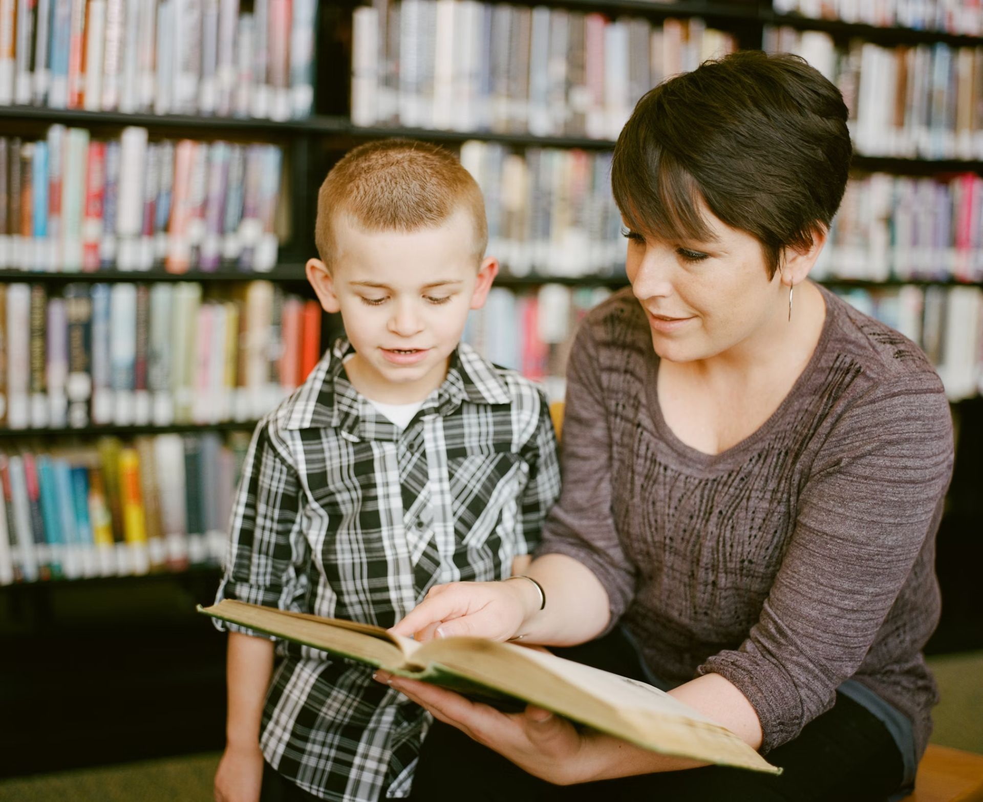Lesend mit Kind in Bibliothek